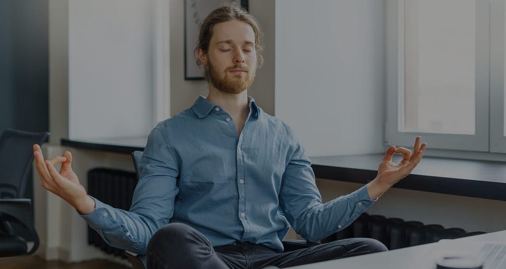 Male network installation professional meditating in office with eyes closed